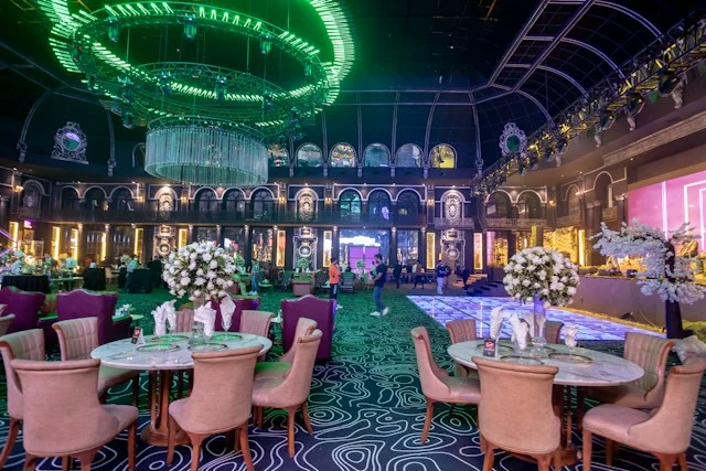 Casino-inspired sculptural floral arrangement beside a carefully set dinner table